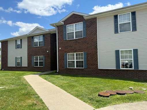 A brick house with a white siding house next to it.
