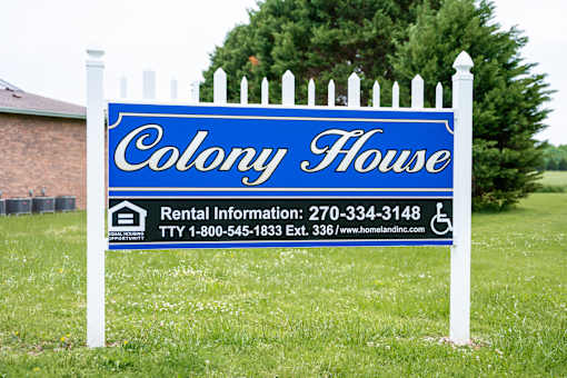 A blue and white sign for Colony House rental with contact information.
