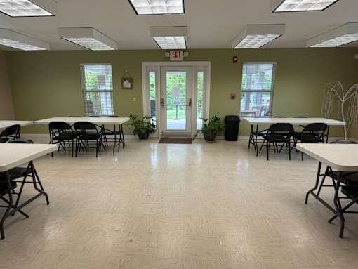 A room with tables and chairs and a door.