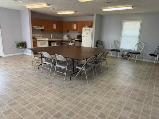 A kitchen with a table and chairs in front of it.