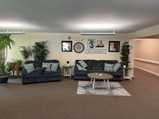 A living room with two couches, a coffee table, and a potted plant.