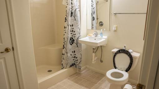 A bathroom with a toilet, sink, and shower curtain.