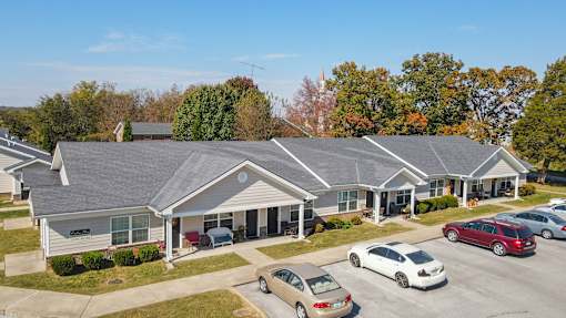 A car dealership with several cars parked in front of the building.
