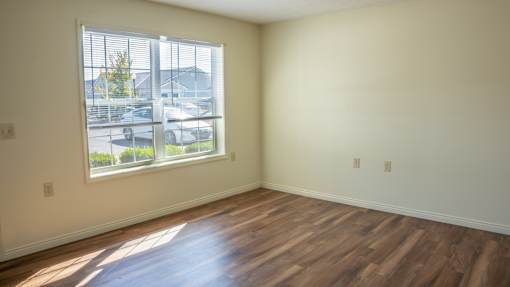 A room with wooden floors and a large window.