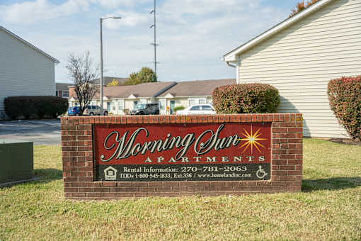 A sign for Morning Sun Apartments with a phone number and website listed.