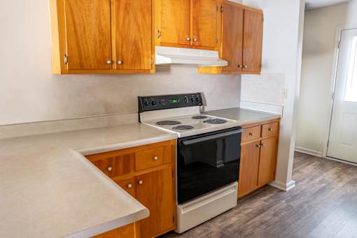 A kitchen with wooden cabinets and a black stove top oven.