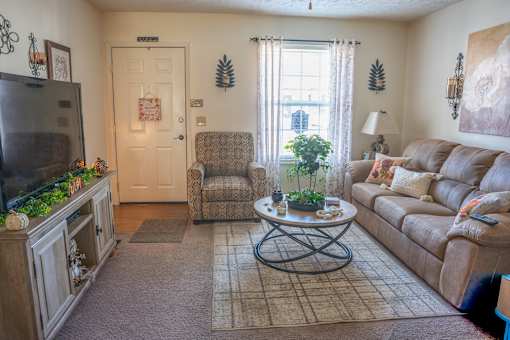 A living room with a brown couch, a television, and a coffee table.