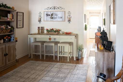 A dining room with a table set for four and a sign that says "Blow All the Candles High".