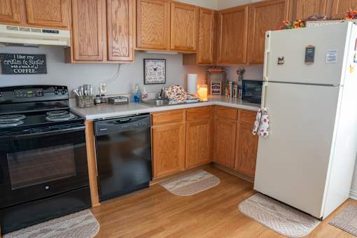A kitchen with wooden cabinets and a fridge.