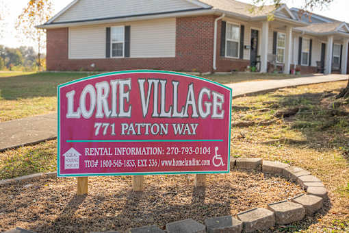 A sign for Lorie Village with rental information and a website.