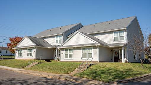 A two-story house with a grey roof and white walls.