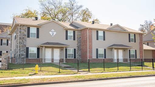 A house with a grey and brown facade is numbered 2.