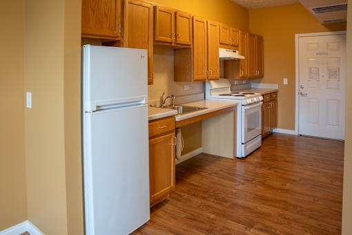 A kitchen with wooden cabinets and white appliances.