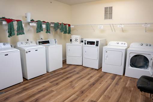 A laundry room with a row of washers and dryers.