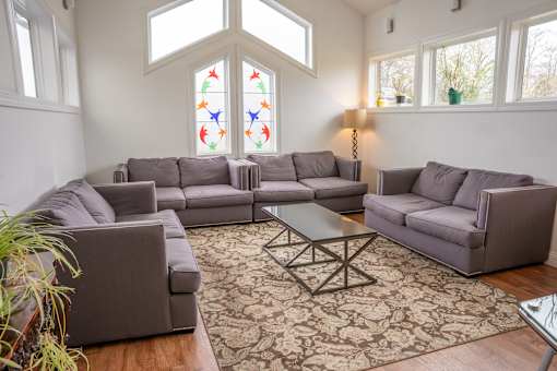 A living room with a grey sectional sofa and a glass coffee table.