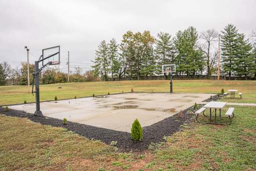 A basketball court with a hoop and a bench.