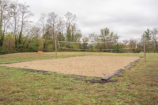 A volleyball court with a net and posts in the middle.