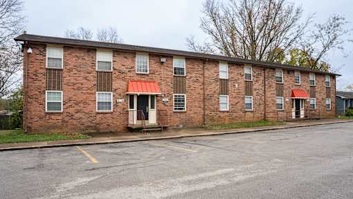 A red brick building with a red awning sits empty.
