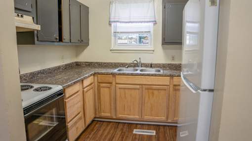 A kitchen with wooden cabinets and a white refrigerator.