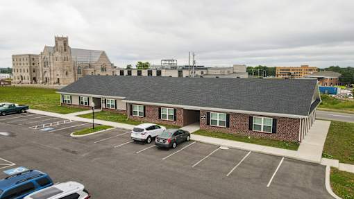 A parking lot with cars and a building in the background.