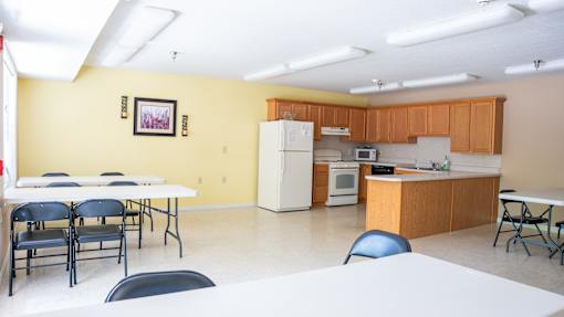 A kitchen with a table and chairs in front of it.