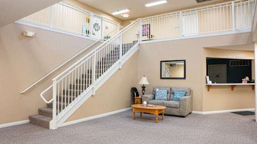 A living room with a staircase leading to the second floor.