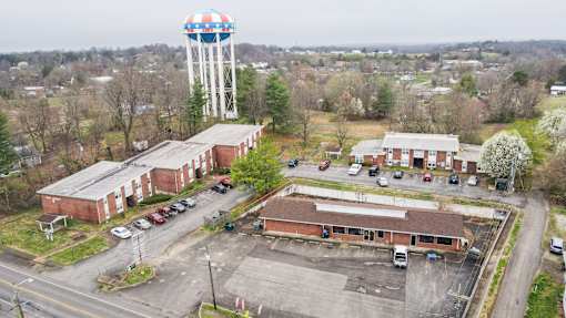 An aerial view of a parking lot with a water tower in the background.
