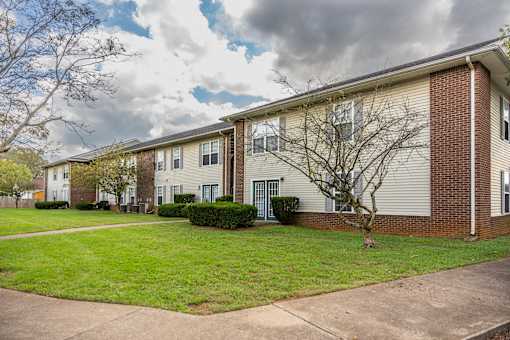 Apartment building with a tree in front.