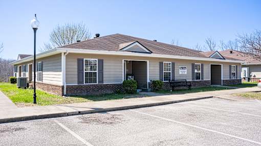 A small building with a parking lot in front.