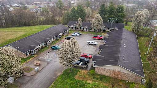 A parking lot with cars and a building in the background.