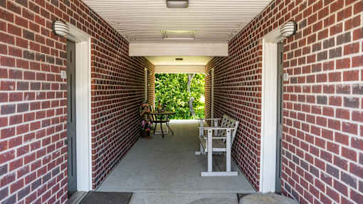 A patio with a table and chairs is enclosed by a brick wall.