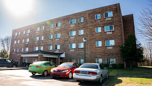 A large brick building with a parking lot in front of it.