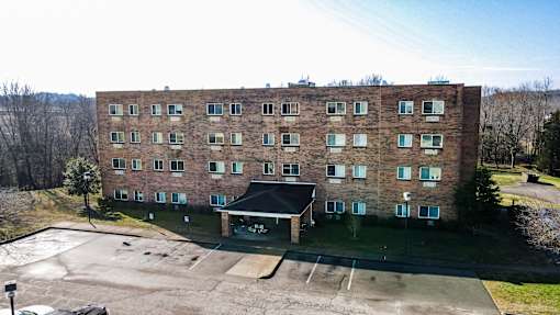 A large brick building with a parking lot in front.