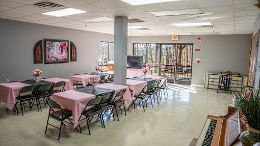 A room with tables and chairs set up for an event.