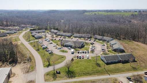 A parking lot with cars and buildings in the distance.