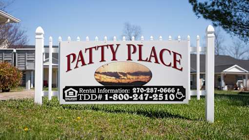 A sign for Patty Place with a picture of a house and rental information.
