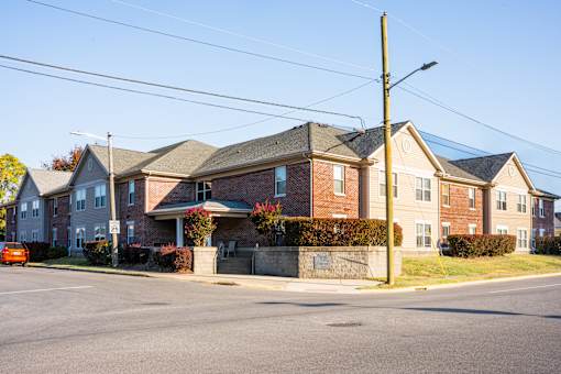 A street view of a residential area with houses and a parked car.