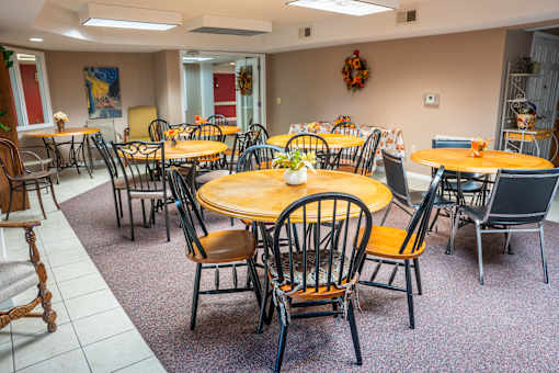 A dining room with tables and chairs.