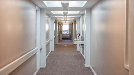 A long hallway with doors on both sides and a carpeted floor.