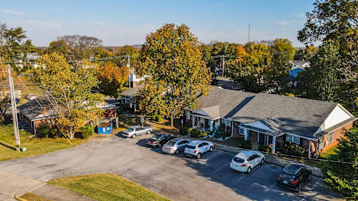 A parking lot with cars and a building in the background.