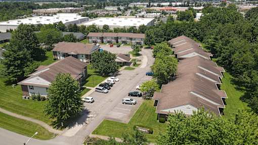 A bird's eye view of a residential area with houses and parked cars.