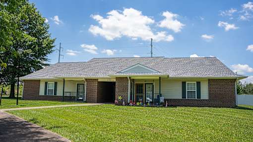 A house with a green lawn and a blue sky.