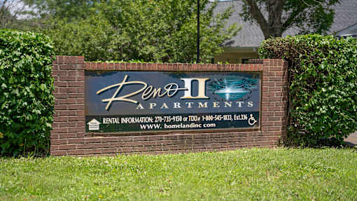 A sign for Ben II Apartments with a phone number and website listed.