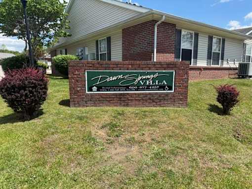 A brick house with a sign that says "Davina Springs Villa" in front of it.