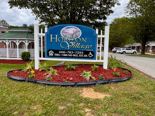 A sign for Horizon Village with a phone number and TDD number on it.
