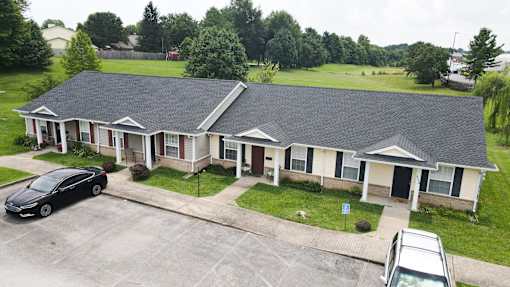 A black car is parked in front of a house.