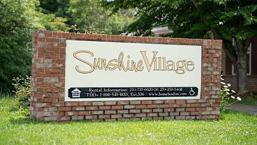 A sign for Sunshire Village with rental information and contact details.
