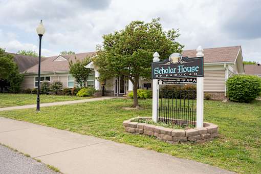 A Scholar House sign is in front of a building.
