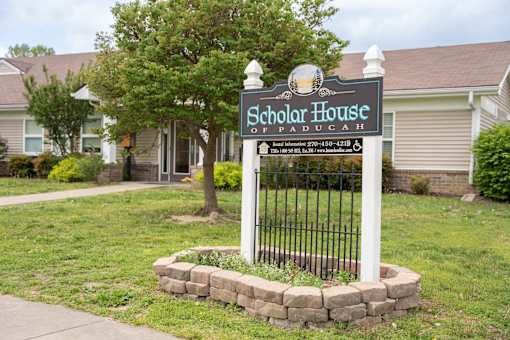 A Scholar House sign is in front of a building.