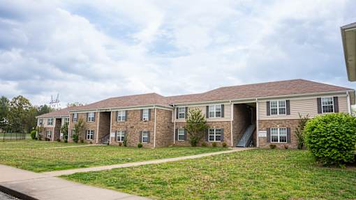 Apartment building with a green lawn in front.